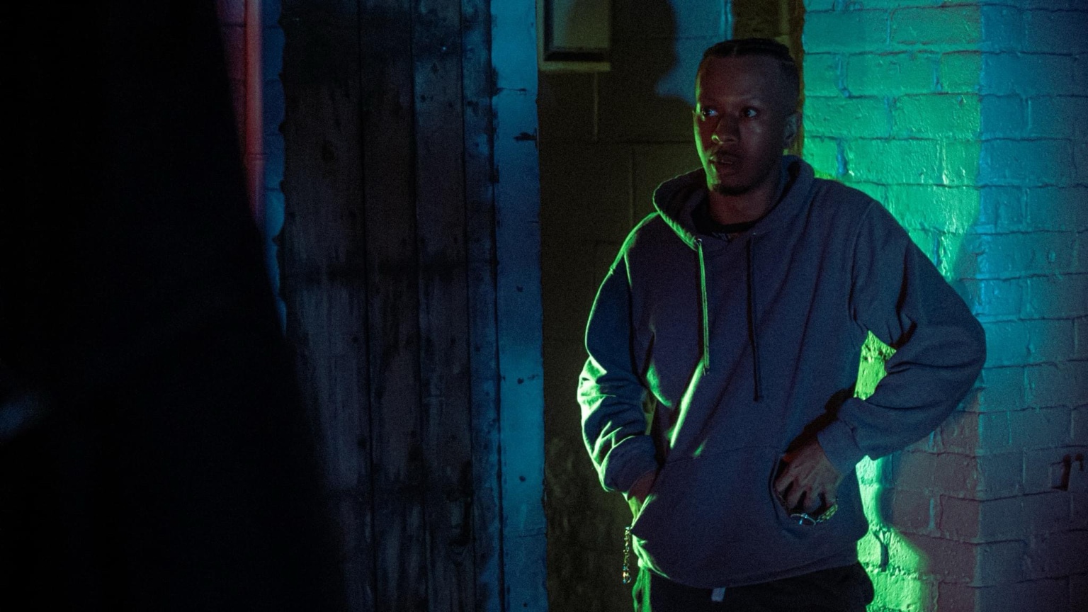 Keenan Laurino in hoodie in neon alleyway