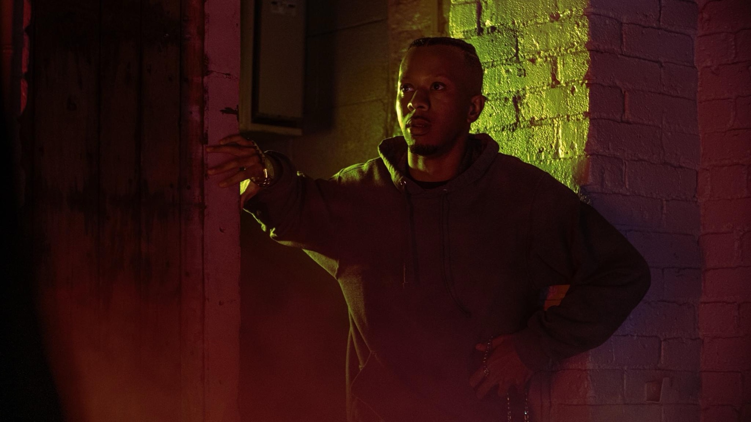 Keenan Laurino framed in doorway with red and yellow light