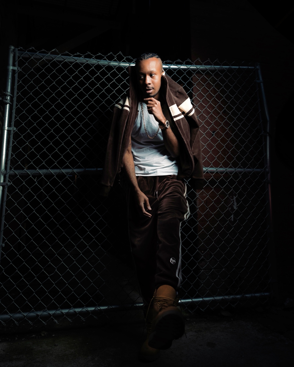 Keenan Laurino leaning by chain link fence