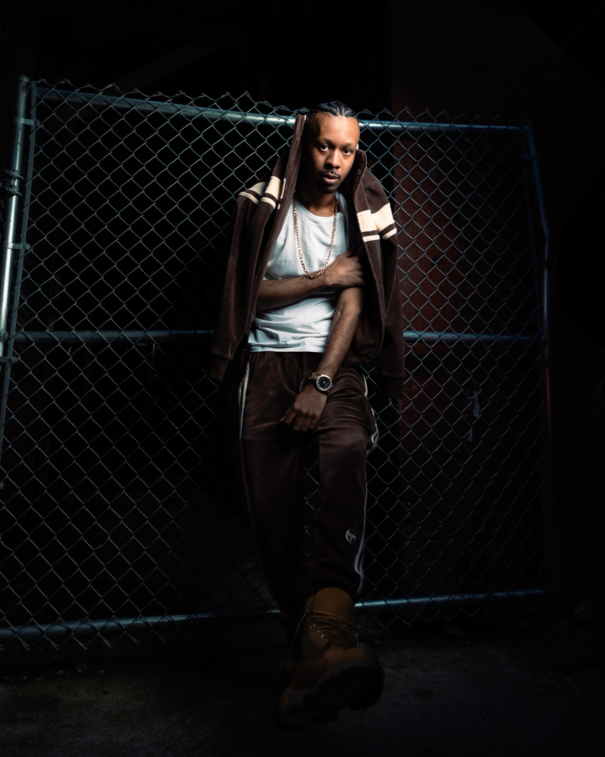 Keenan Laurino in tracksuit and boots by fence